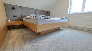 Podkrovní ložnice s postelí a šatnou